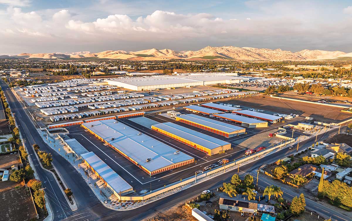 An aerial view of a sprawling industrial storage facility with mountains in the background.