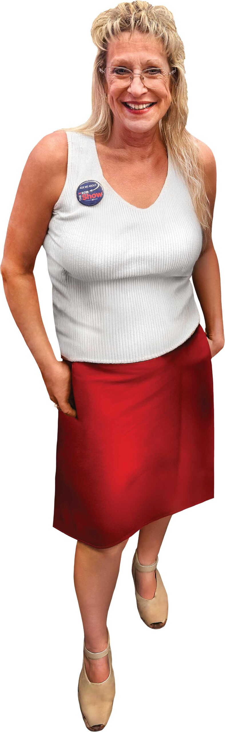 A smiling woman wearing a white top, red skirt, and a promotional badge.
