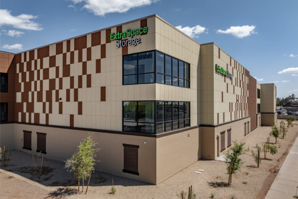 Exterior of a multi-story Extra Space Storage building featuring cream walls with a brown checkered pattern design.