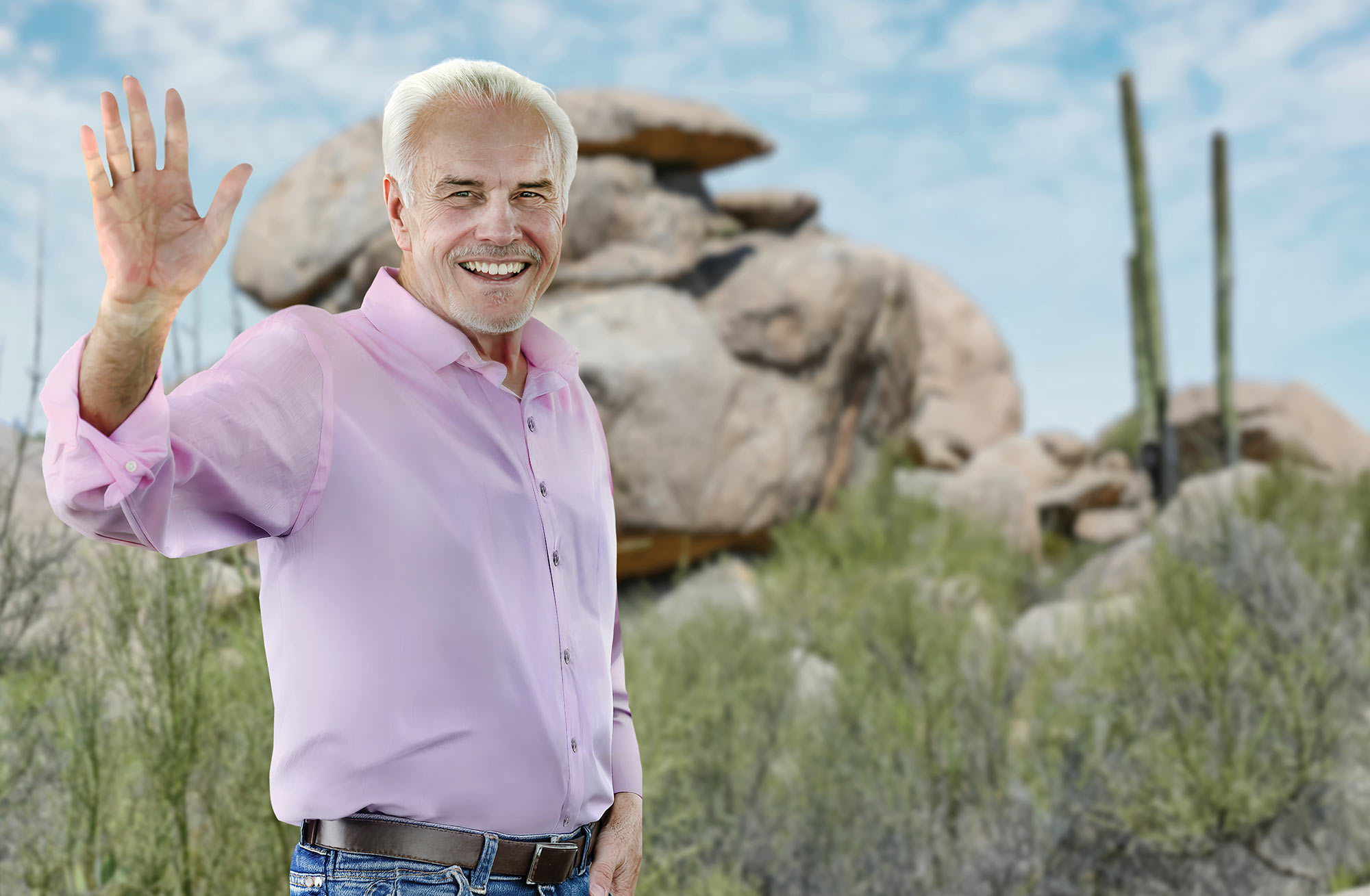 Mike Schofield waving in a desert landscape.