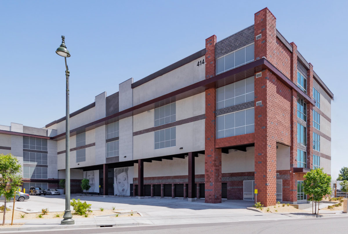 Wide exterior shot of a storage facility featuring portrait murals.