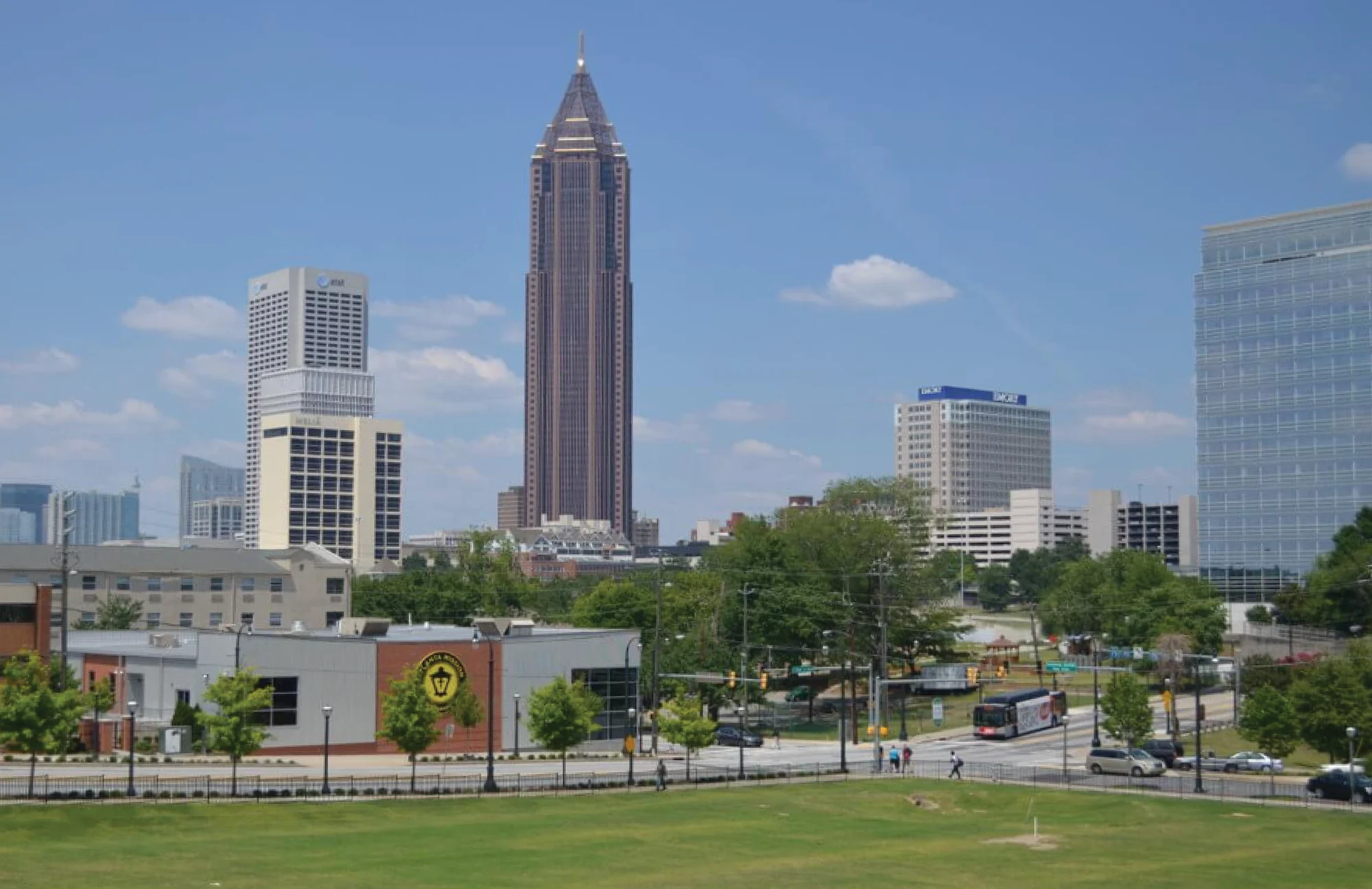 Wide-angle view of the Atlanta city skyline with skyscrapers under a blue sky.