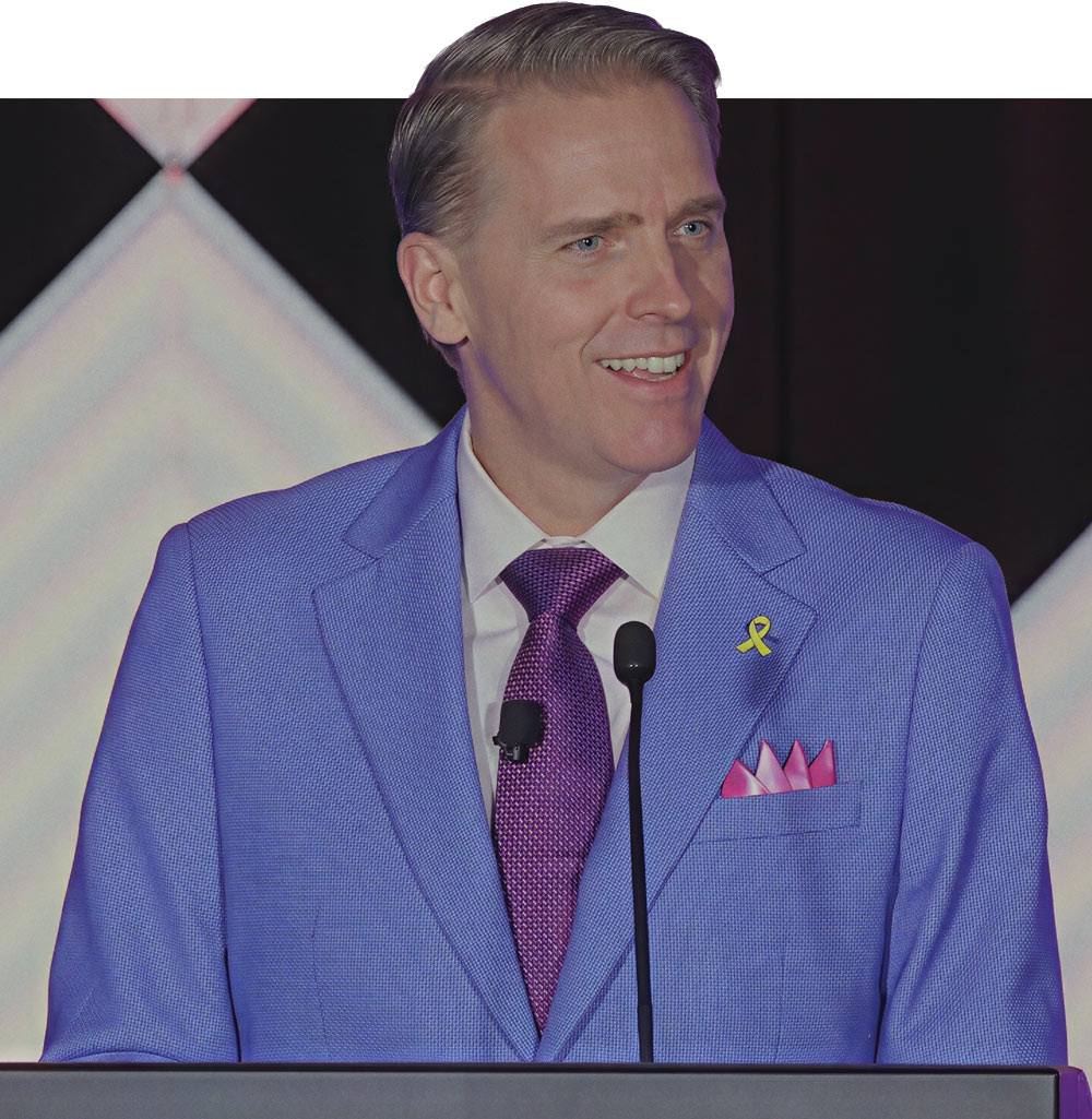 Scott Jennings smiling at a podium during a public speaking event.