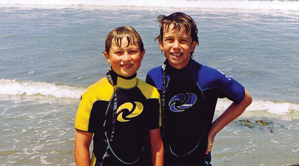 Ryan Chapman and Clay Jones as children in surfing wetsuits.
