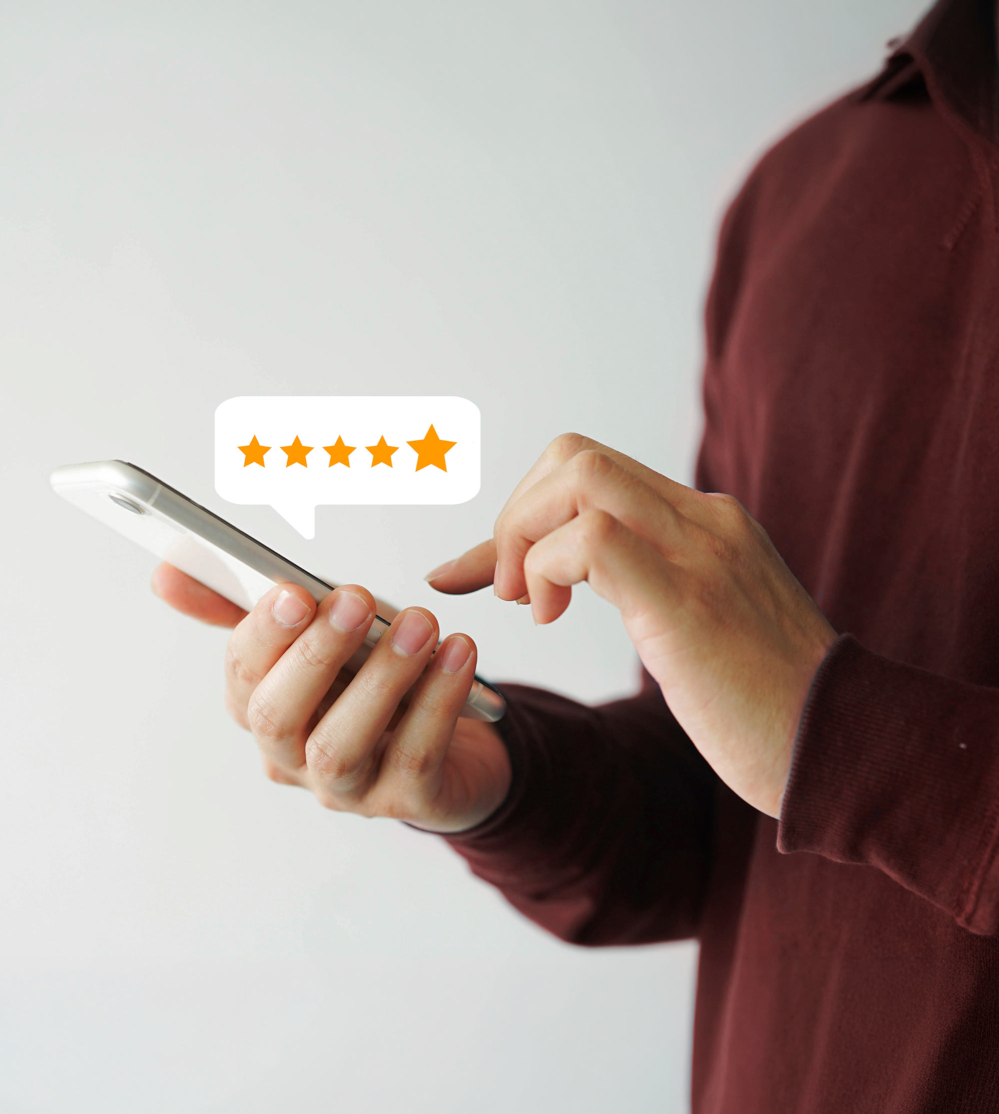 Person Holding A Smartphone Displaying A Five Star Rating Graphic Bubble.