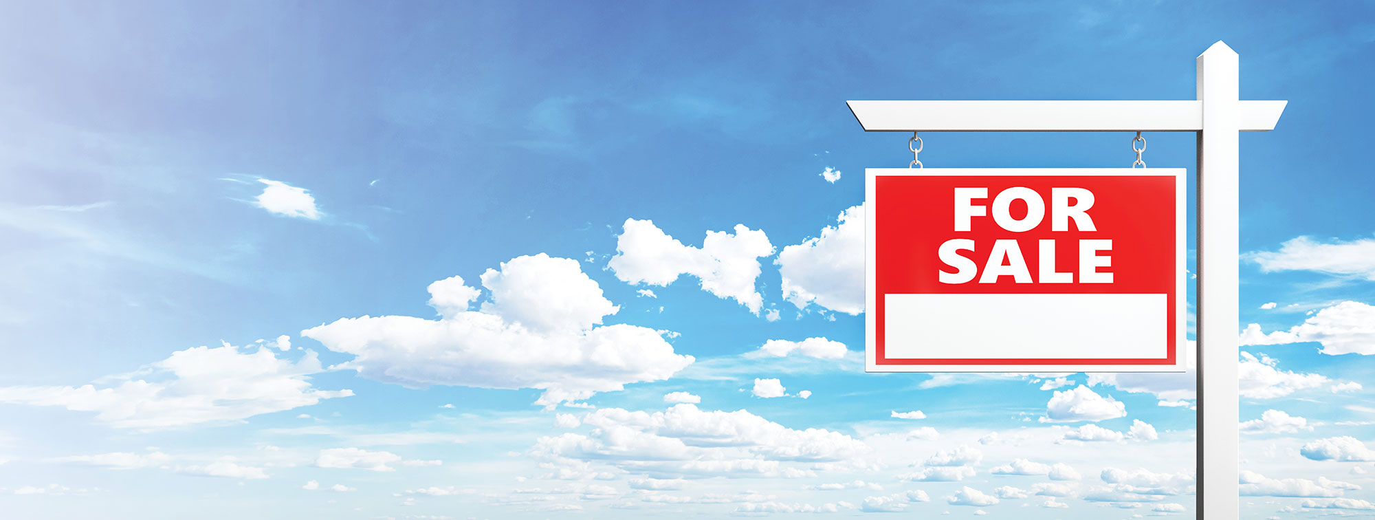 Red and white for sale real estate sign against a cloudy blue sky.