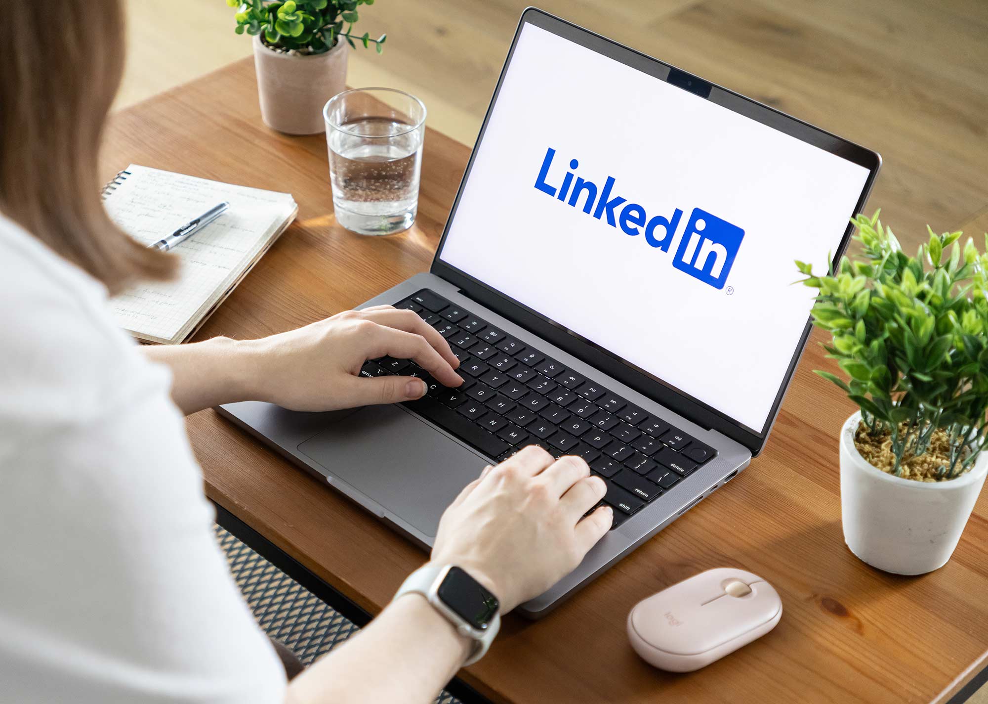 Person using a laptop with the LinkedIn logo displayed on the screen.