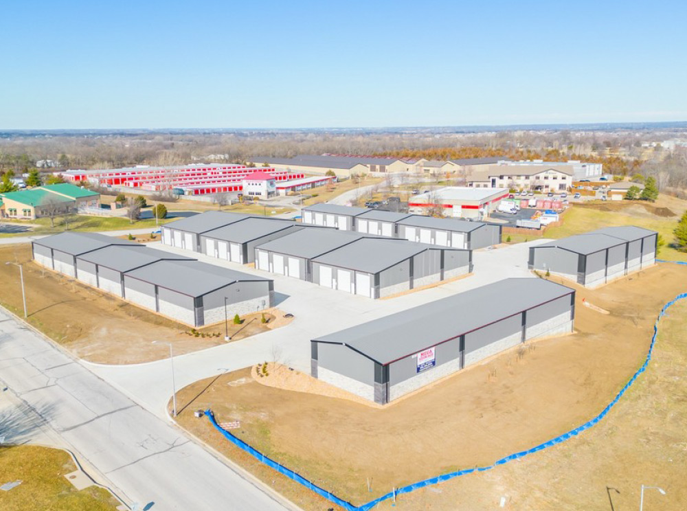 High aerial photograph of a large self-storage facility complex with multiple gray-roofed buildings.