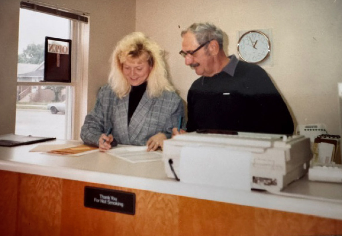 Sue Haviland working at an office counter alongside a man.