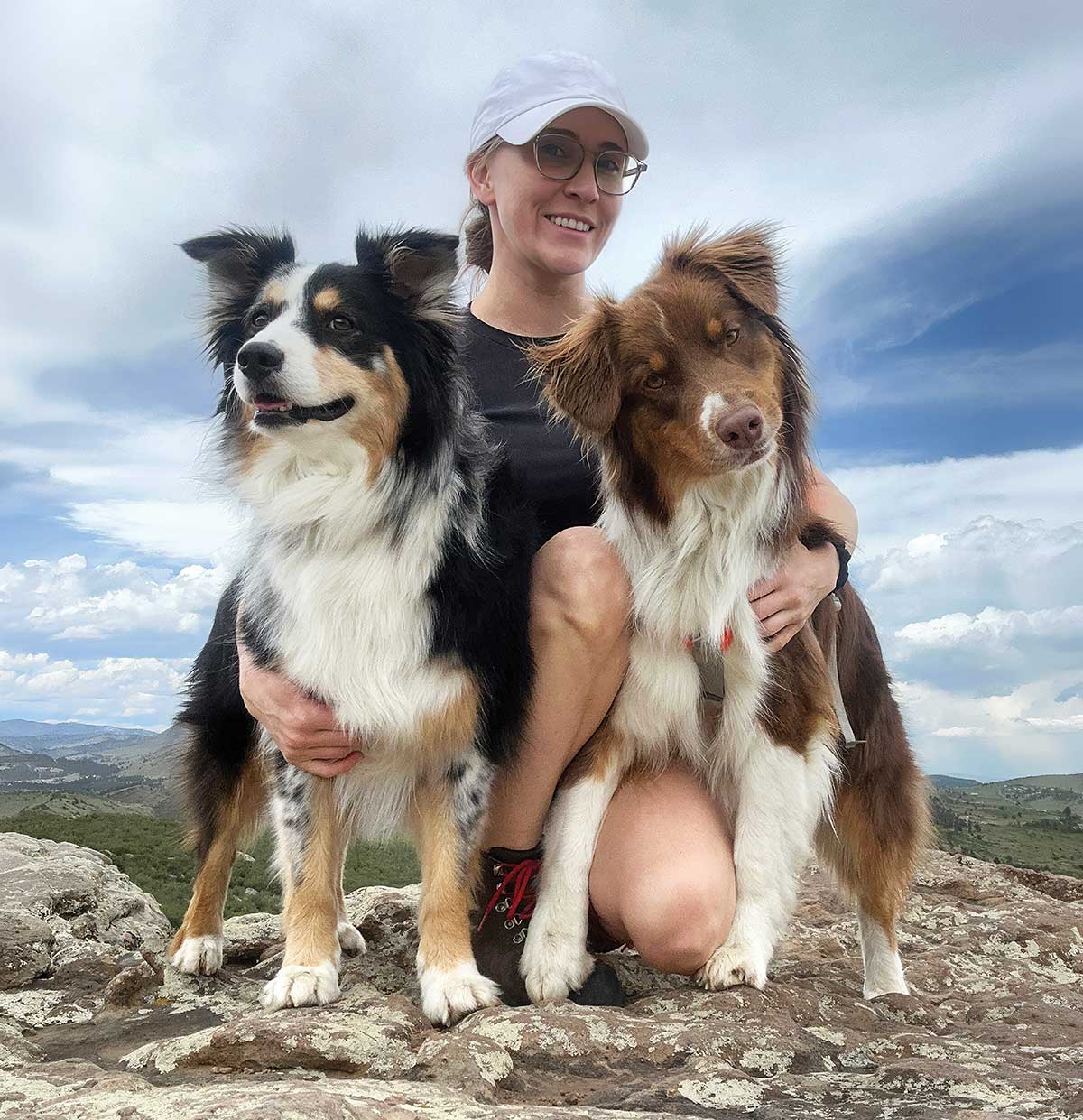 Jessie Smith with her two dogs, Cricket and Scooter, in a mountainous landscape.