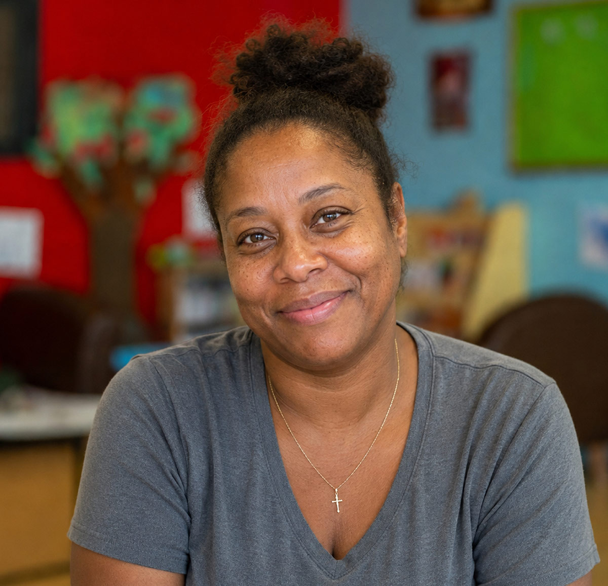 Warm portrait of Latasha smiling with a blurred colorful background.